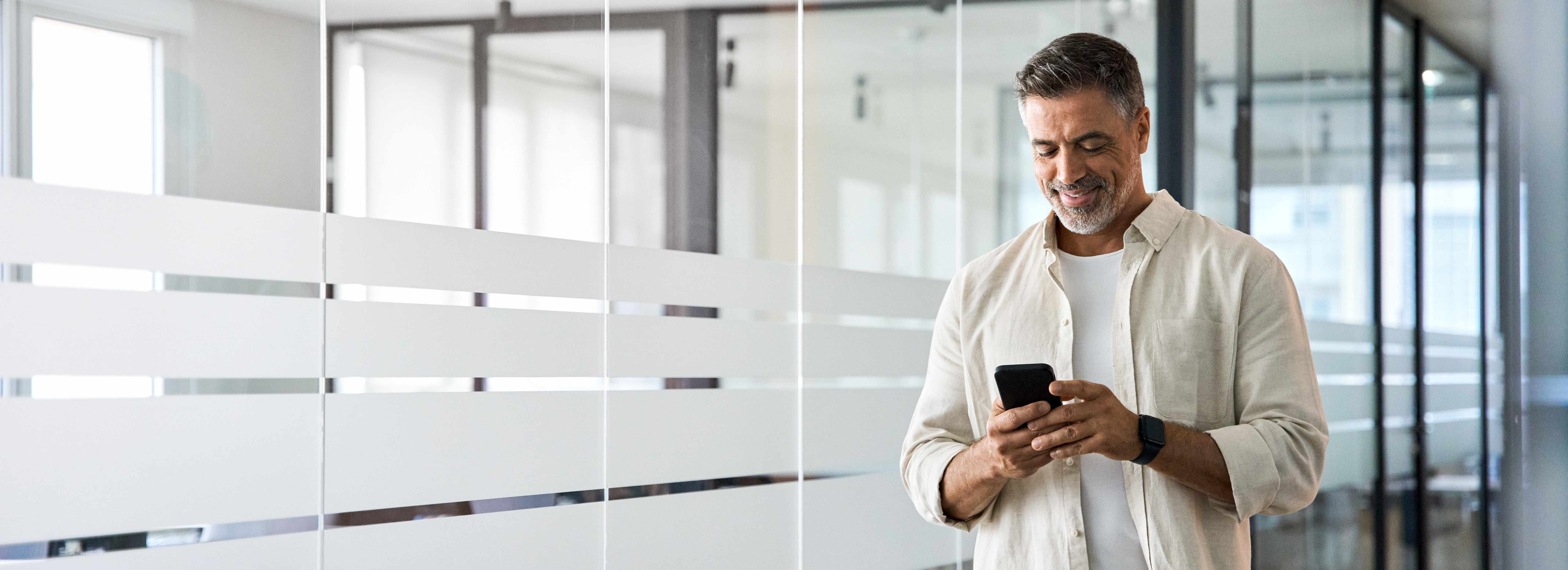 Man in office holding a phone