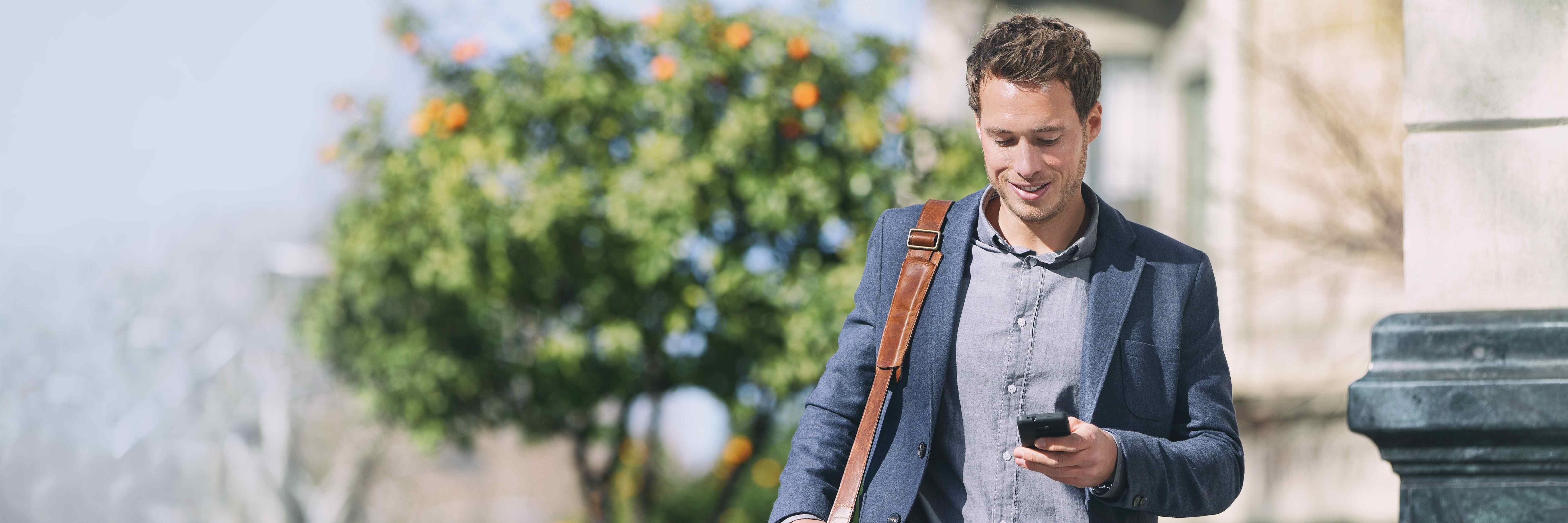 Man outside holding a phone