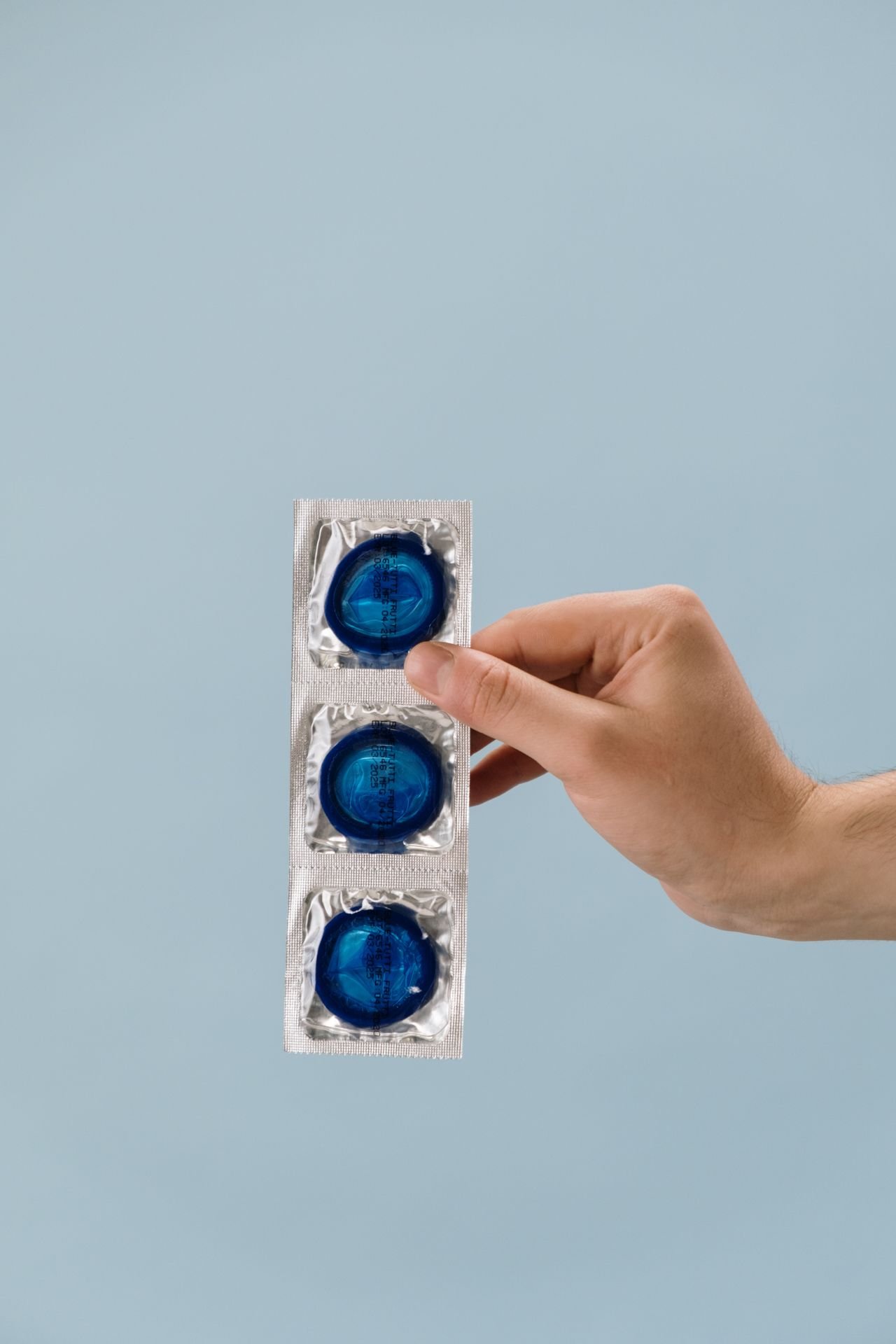 Hand picking up a blister pack of the morning-after pill from a table