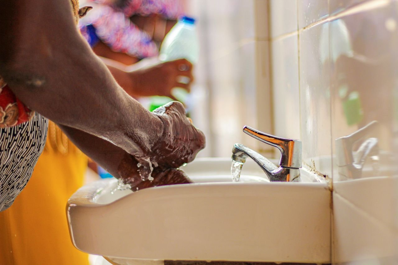 Close-up of hands being washed under a running tap