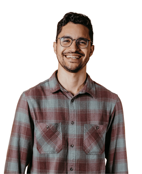 Man in a checked shirt with glasses and a beard against a light cream backdrop
