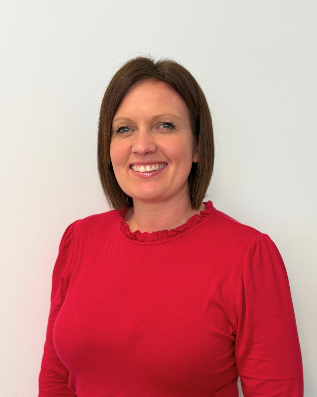 Headshot of Sarah King, Advanced Clinical Practitioner Clinical Lead, smiling in a red top