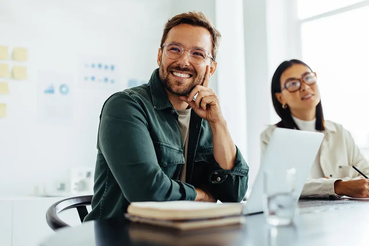 man smiling with laptop in office