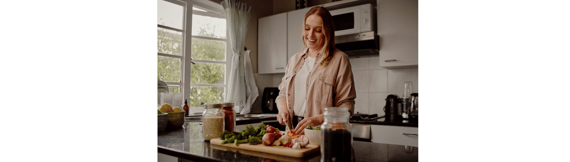 Woman in kitchen cutting healthy vegetables
