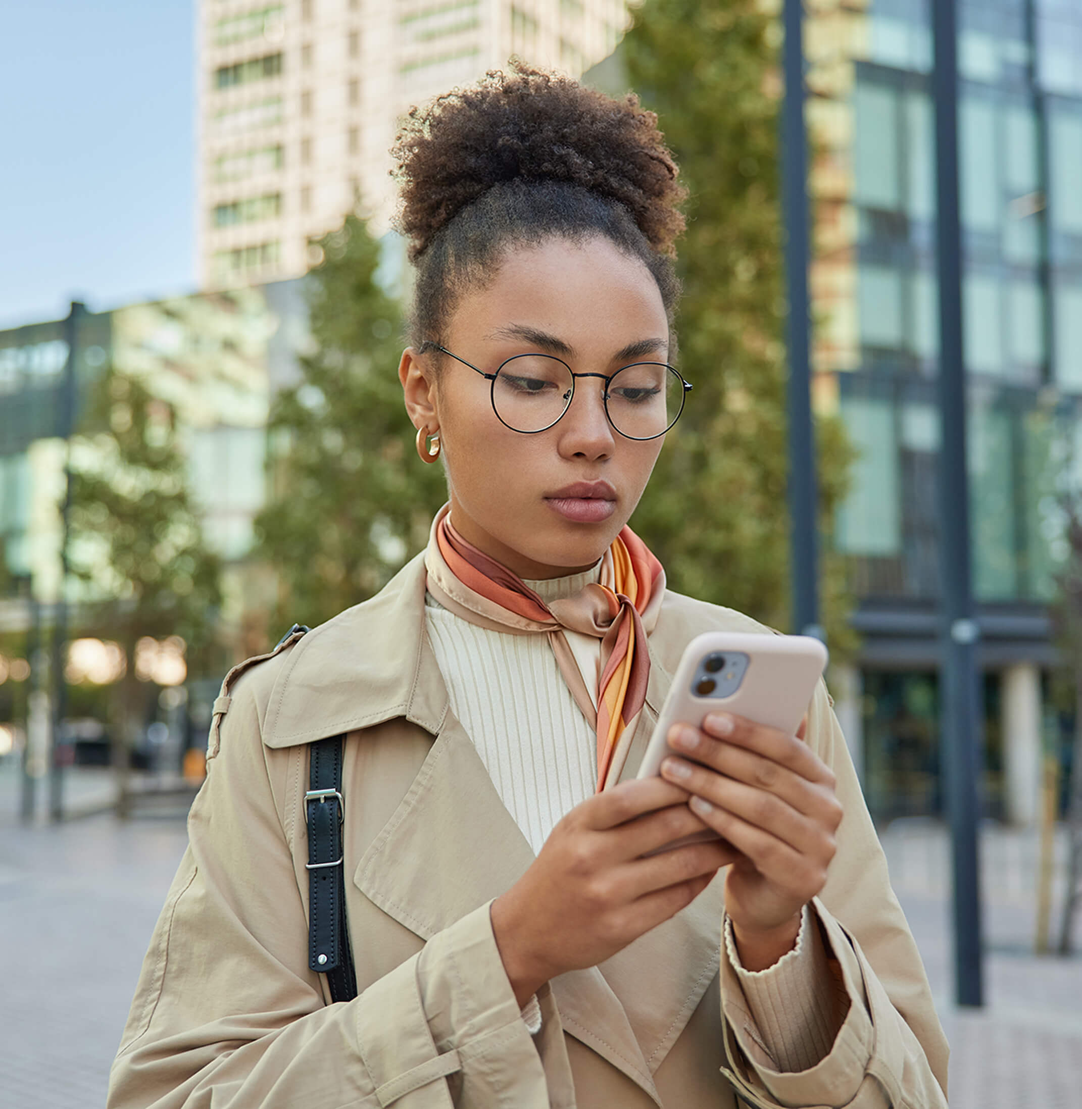 Curly haired female presenting person on phone in public