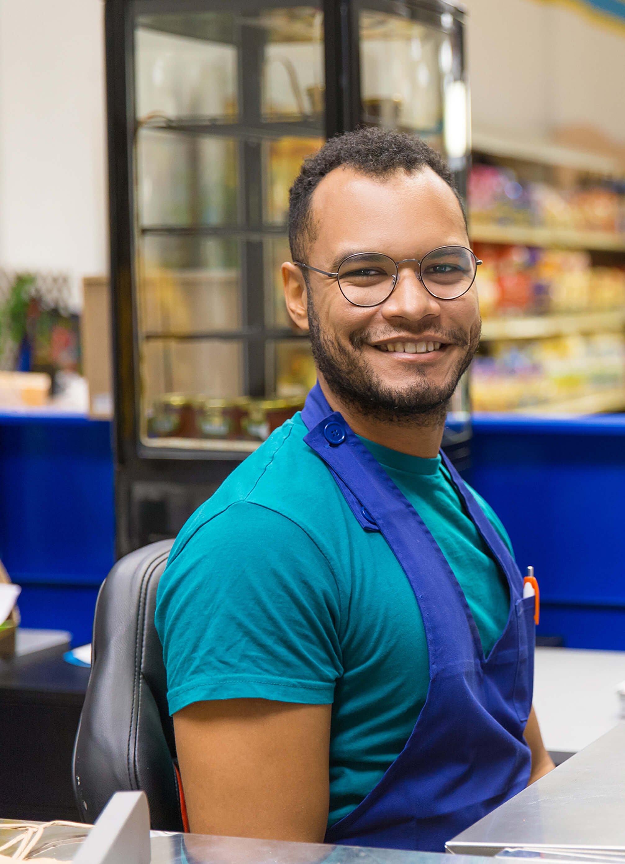 Male in store smiling behind register