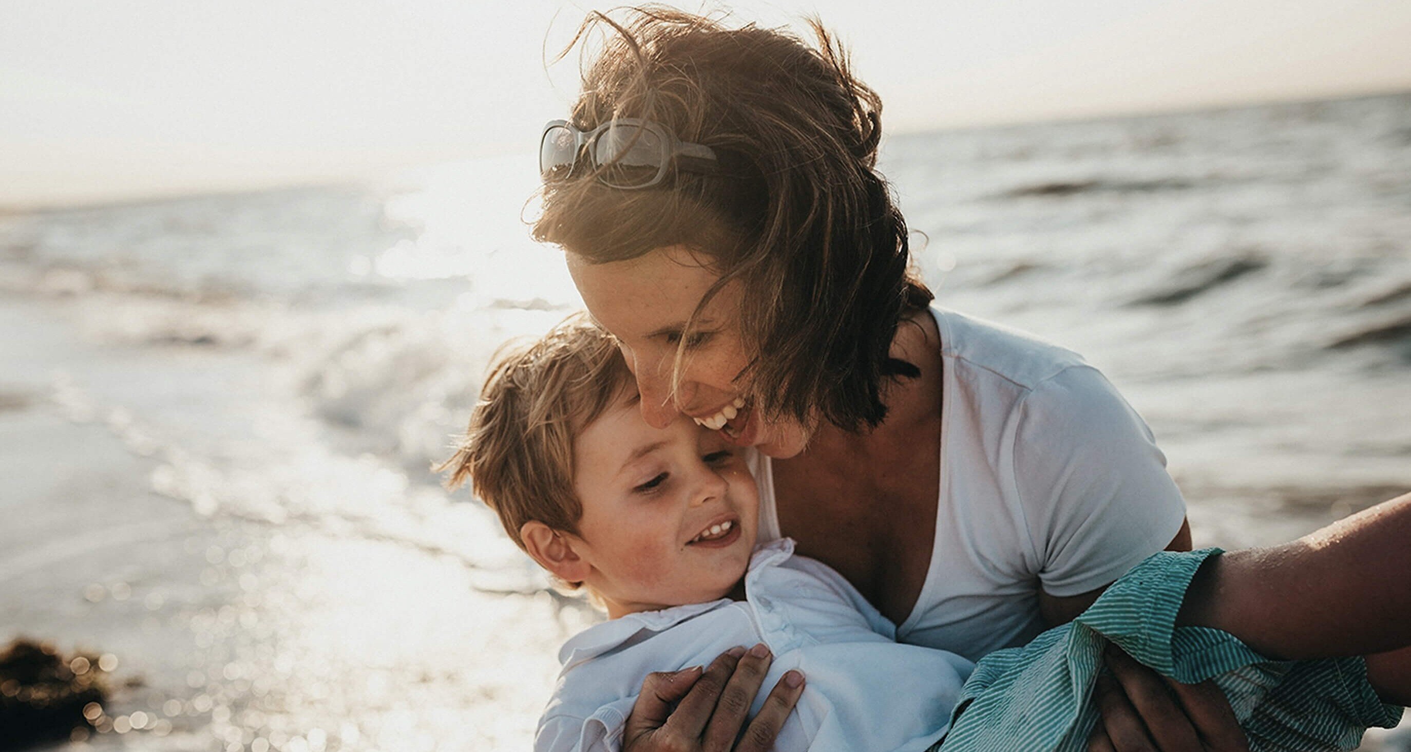 Mother and son smiling at the beach