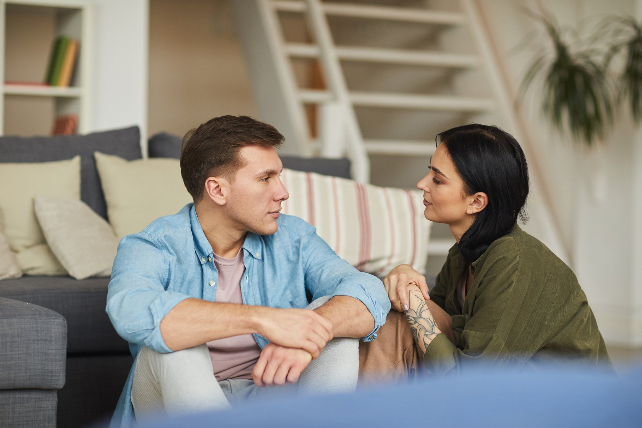 Young couple sat on the floor of their home