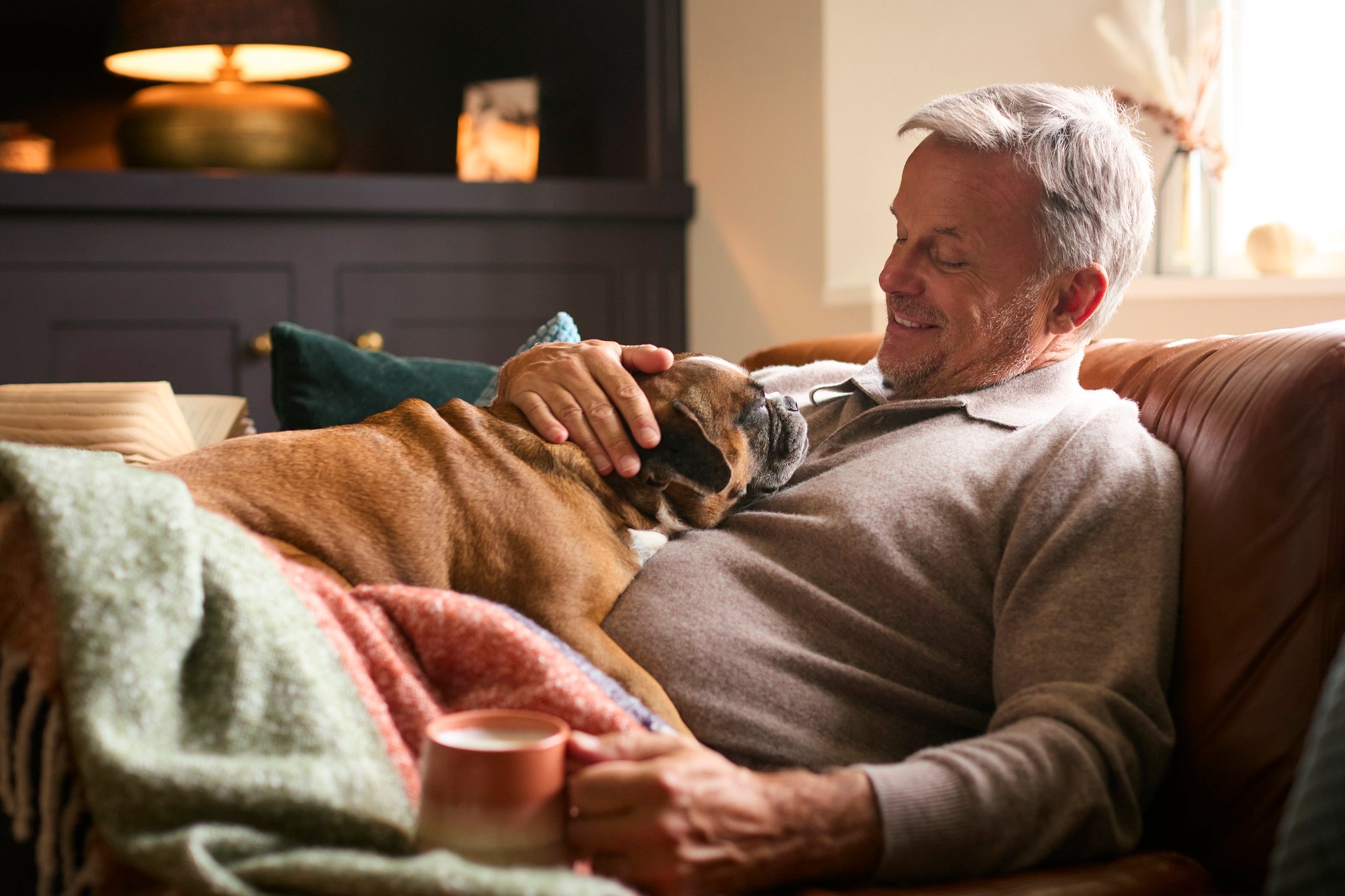 A man and his dog lounging on the sofa