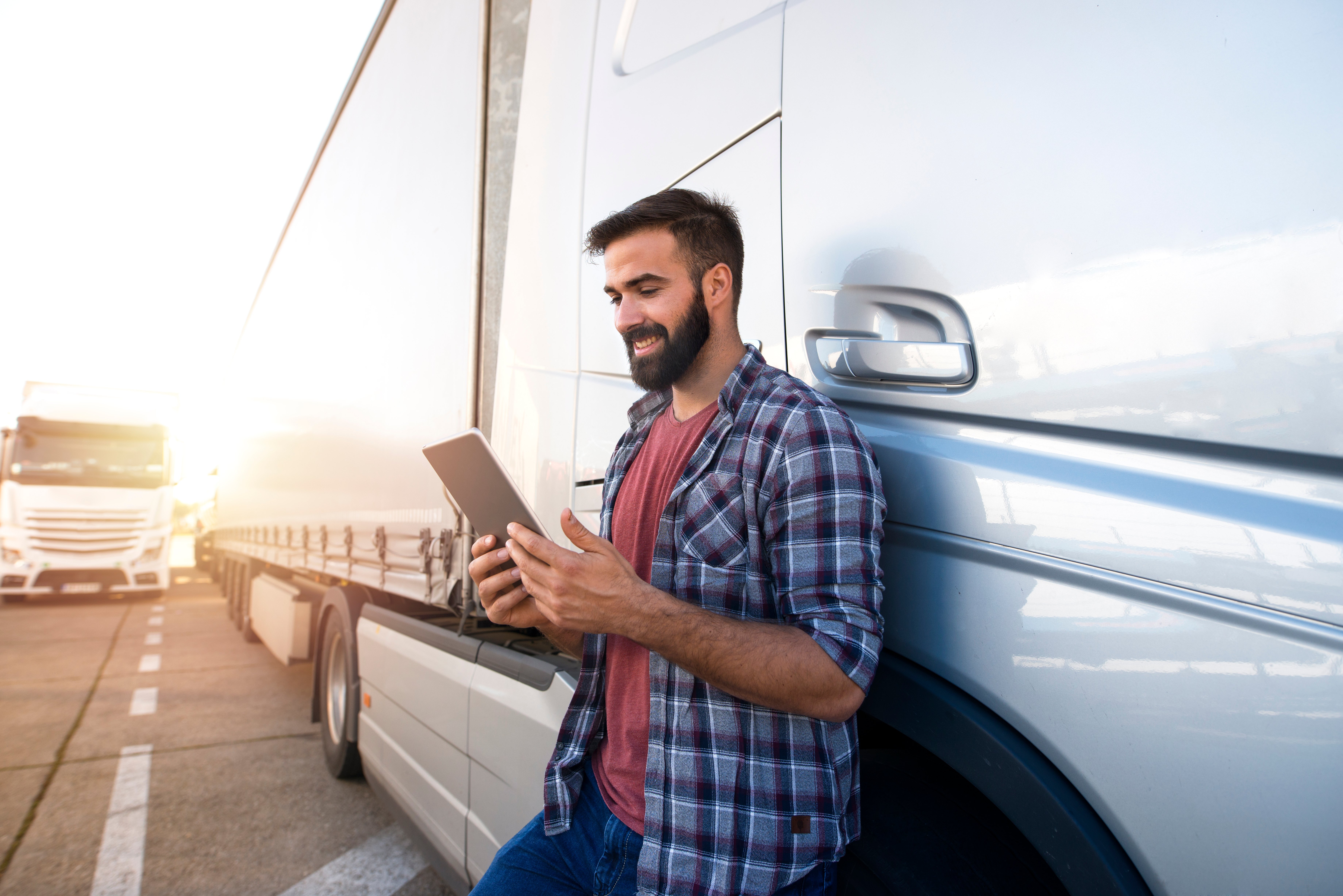 Man next to truck holding an ipad