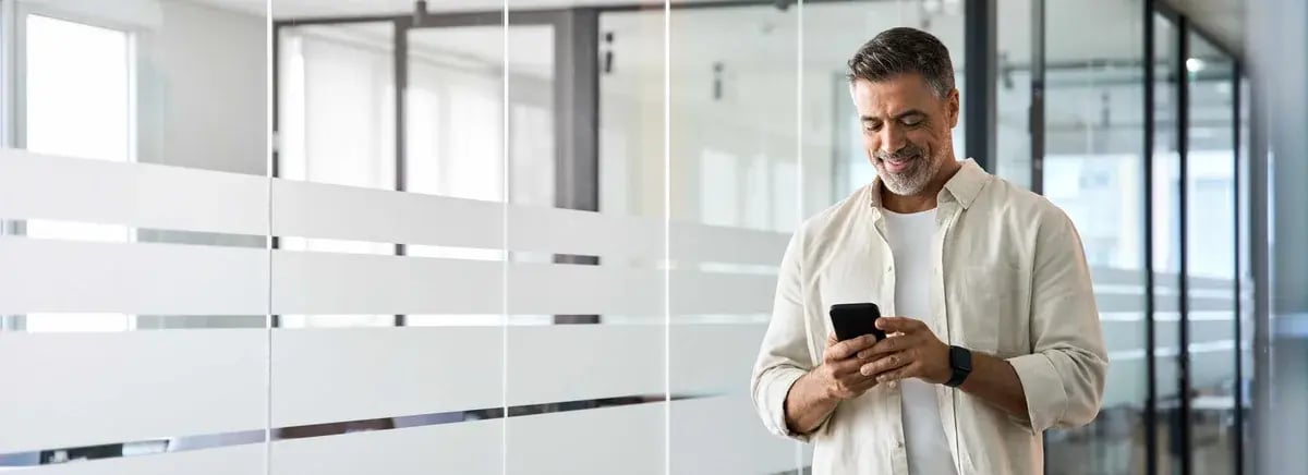 Man in office holding a phone