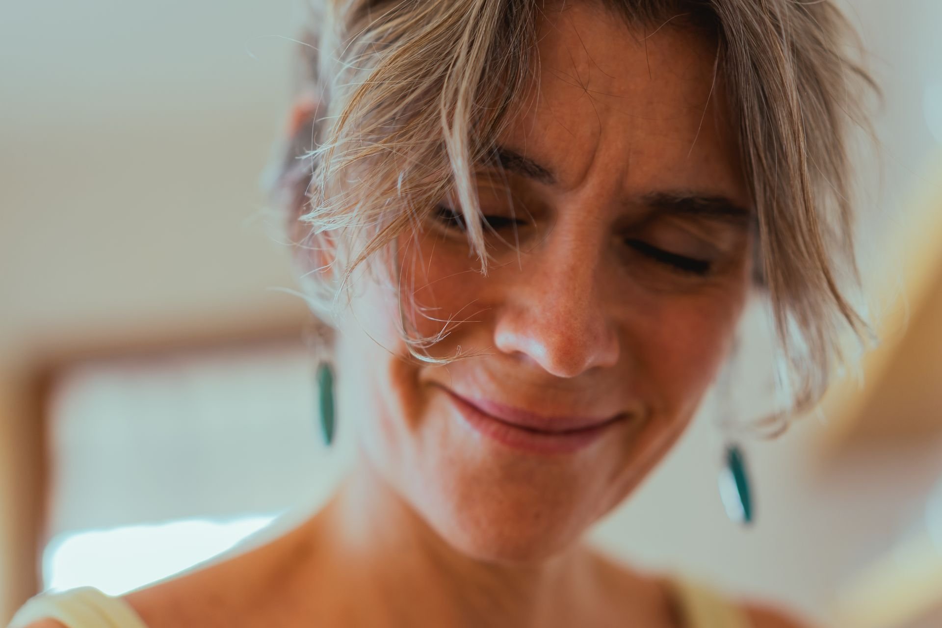 lose-up of a woman with tousled hair smiling gently