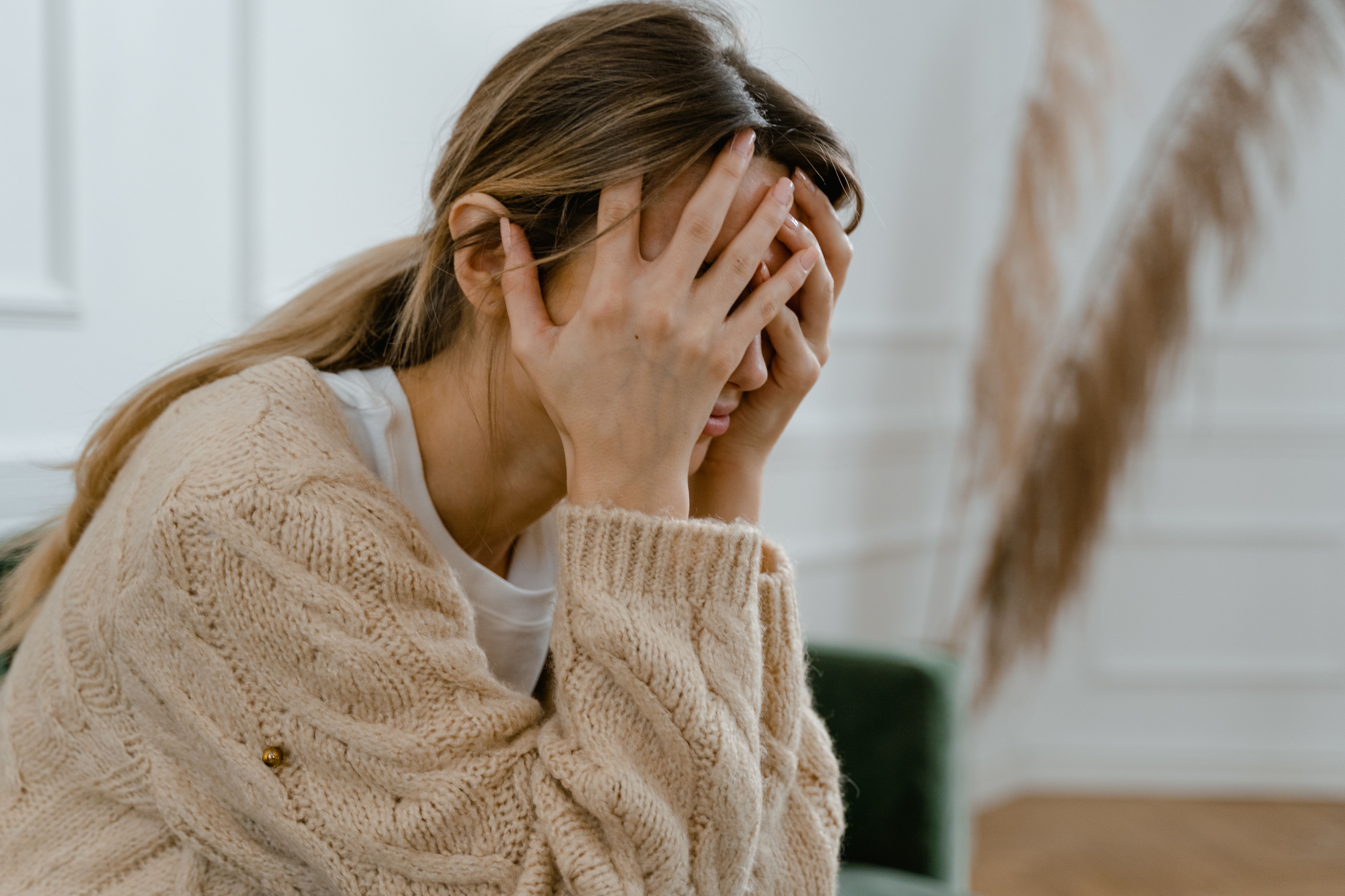 Woman with her head in her hands, appearing stressed or overwhelmed